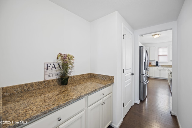 bar featuring baseboards, dark wood-style flooring, and stainless steel fridge
