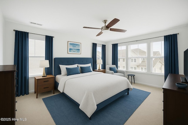 bedroom with light colored carpet, multiple windows, and visible vents