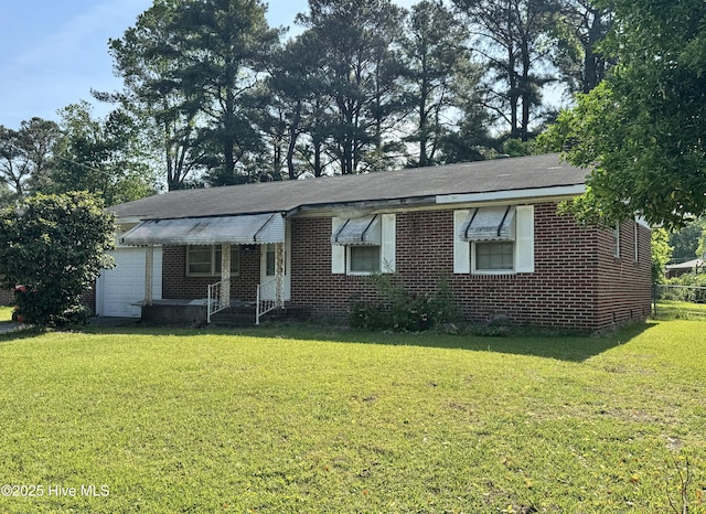 single story home featuring brick siding, a front lawn, and a garage