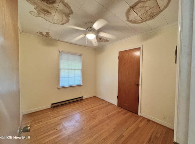 unfurnished bedroom with a ceiling fan, light wood-type flooring, baseboards, a baseboard heating unit, and ornamental molding