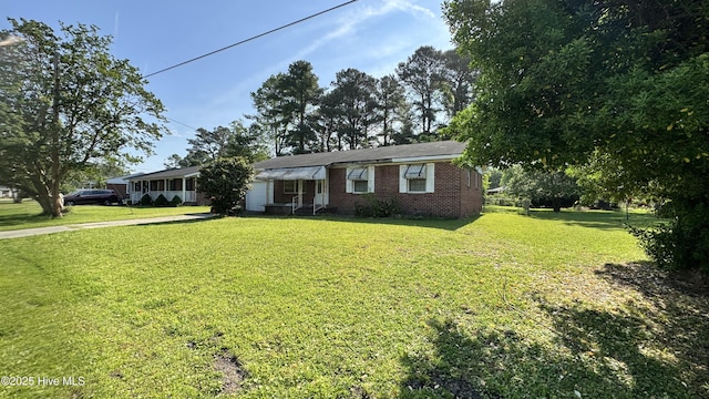 ranch-style home with a garage, concrete driveway, a front lawn, and brick siding