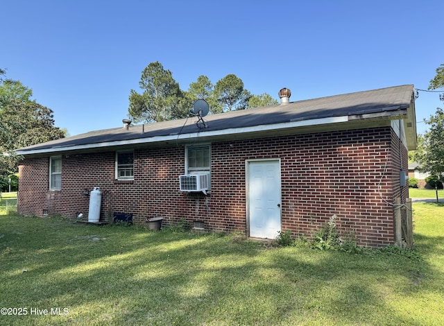 rear view of property with brick siding and a yard