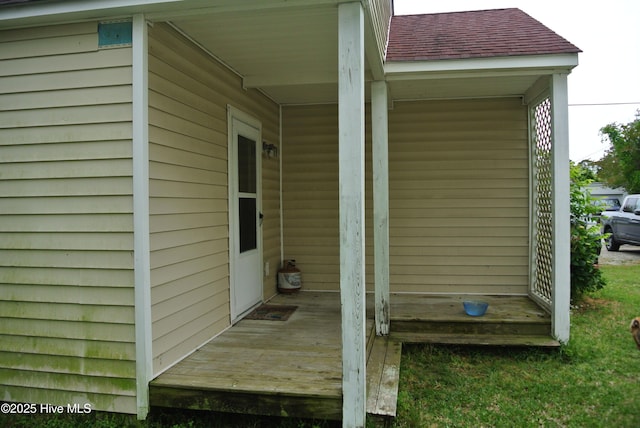 doorway to property with roof with shingles