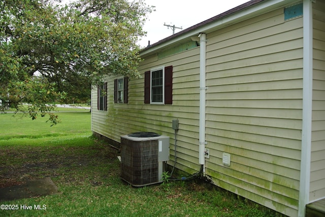 view of property exterior featuring a lawn and central AC unit