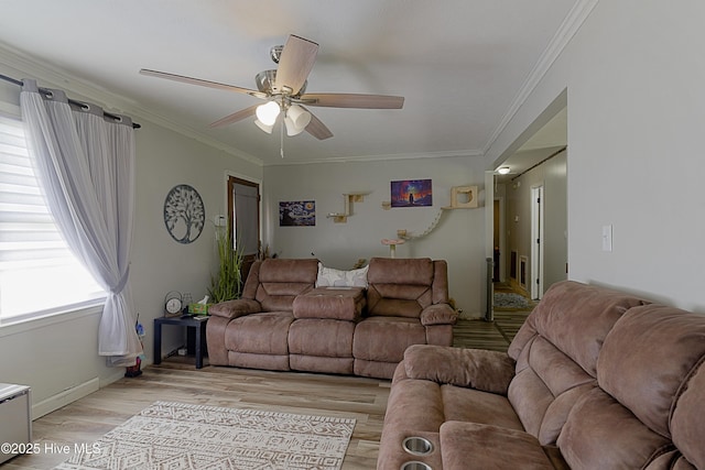 living room featuring light wood-style flooring, ornamental molding, ceiling fan, and baseboards
