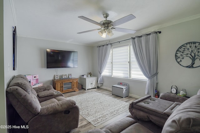 living room with light wood-type flooring, baseboards, a ceiling fan, and ornamental molding