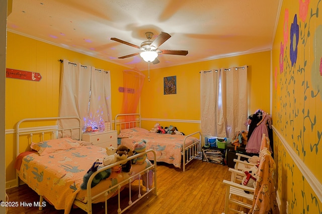 bedroom featuring crown molding, wood finished floors, and a ceiling fan