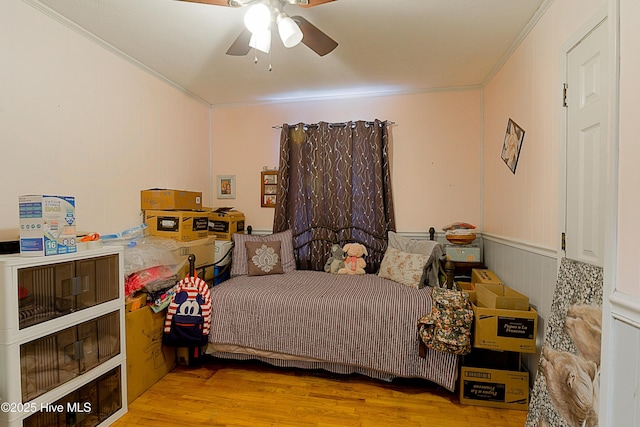 bedroom featuring crown molding, wood finished floors, and a ceiling fan