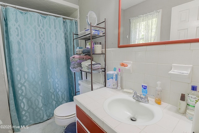 full bath featuring a shower with shower curtain, vanity, tile walls, and toilet