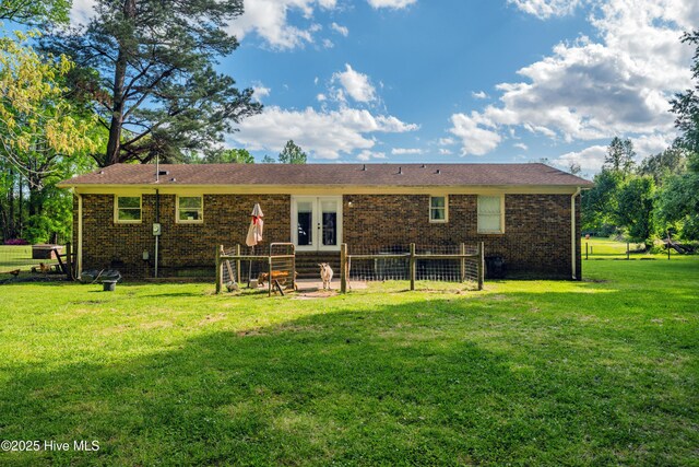back of house with a yard, french doors, and brick siding
