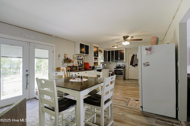 dining space with light wood finished floors, french doors, and ceiling fan