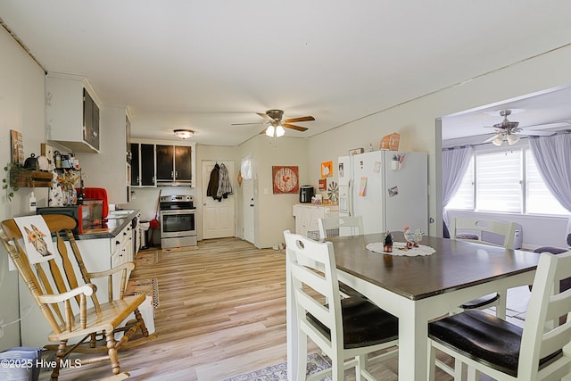 dining space with light wood finished floors and ceiling fan