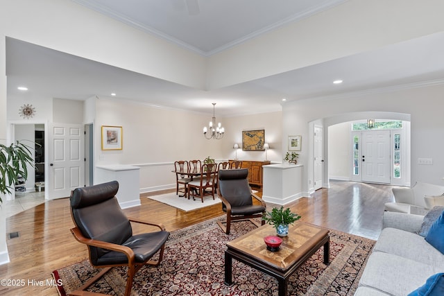 8819 Sawmill Creek Ln, Wilmington, NC 28411 - living room with arched walkways, light wood-type flooring, crown molding, a chandelier, and baseboards