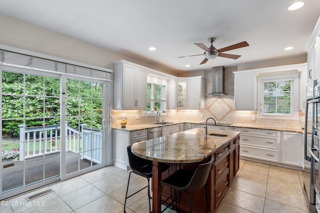 8819 Sawmill Creek Ln, Wilmington, NC 28411 - kitchen featuring wall chimney exhaust hood, ceiling fan, backsplash, stainless steel dishwasher, and light tile patterned floors