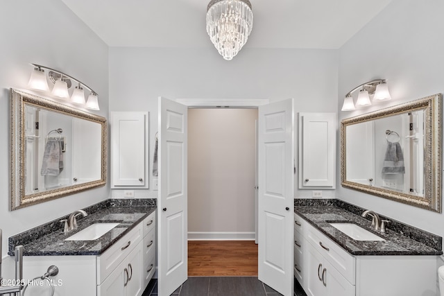8819 Sawmill Creek Ln, Wilmington, NC 28411 - bathroom featuring two vanities, a chandelier, wood finished floors, and baseboards