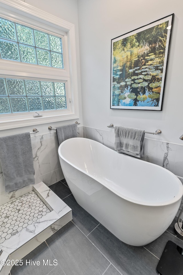 8819 Sawmill Creek Ln, Wilmington, NC 28411 - full bathroom featuring tile walls, a wainscoted wall, a freestanding bath, and tile patterned floors