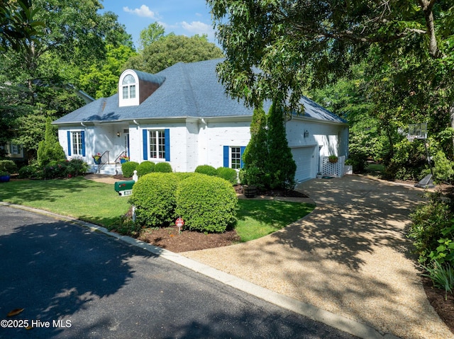 8819 Sawmill Creek Ln, Wilmington, NC 28411 - cape cod-style house with an attached garage, a front yard, driveway, a shingled roof, and brick siding