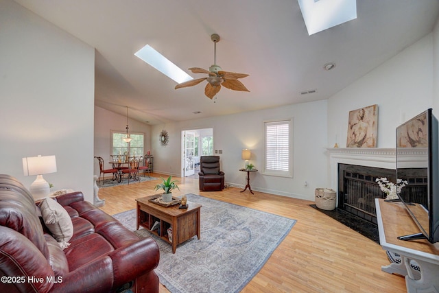 5029 Woods Edge Rd, Wilmington, NC 28409 - living area with a skylight, wood finished floors, ceiling fan, visible vents, and a fireplace with flush hearth