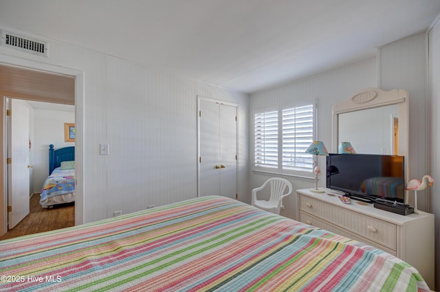bedroom featuring visible vents, wood finished floors, and a closet