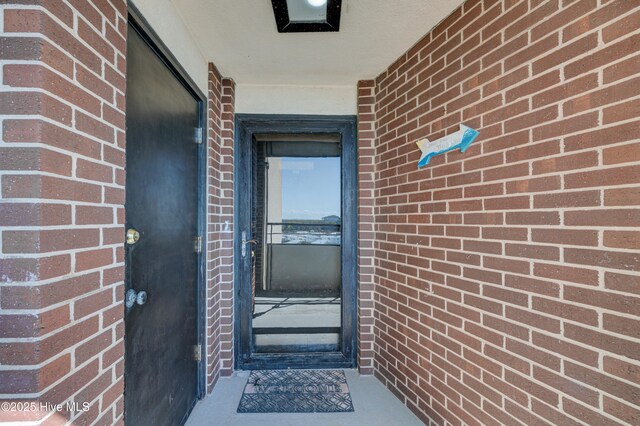 property entrance featuring brick siding