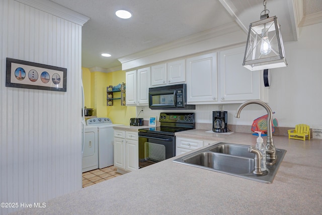 kitchen with a sink, black appliances, white cabinetry, and washer and dryer
