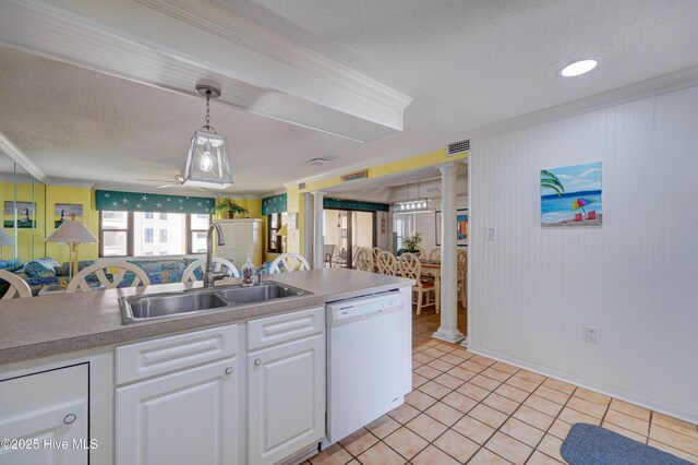 kitchen with decorative columns, ceiling fan, white cabinetry, a sink, and dishwasher