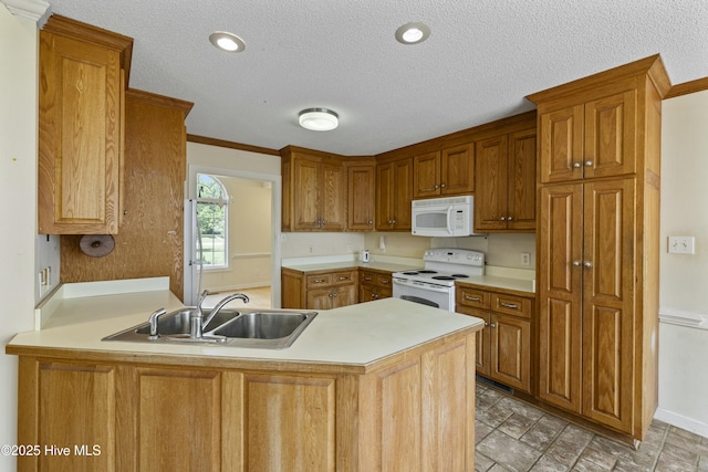 kitchen featuring a sink, light countertops, white appliances, and a peninsula