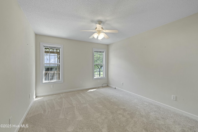 carpeted spare room with baseboards, a textured ceiling, and a ceiling fan