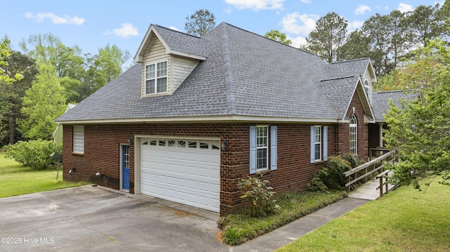 view of side of home with roof with shingles, brick siding, driveway, and a lawn