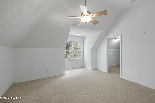 additional living space with a ceiling fan, carpet flooring, and lofted ceiling