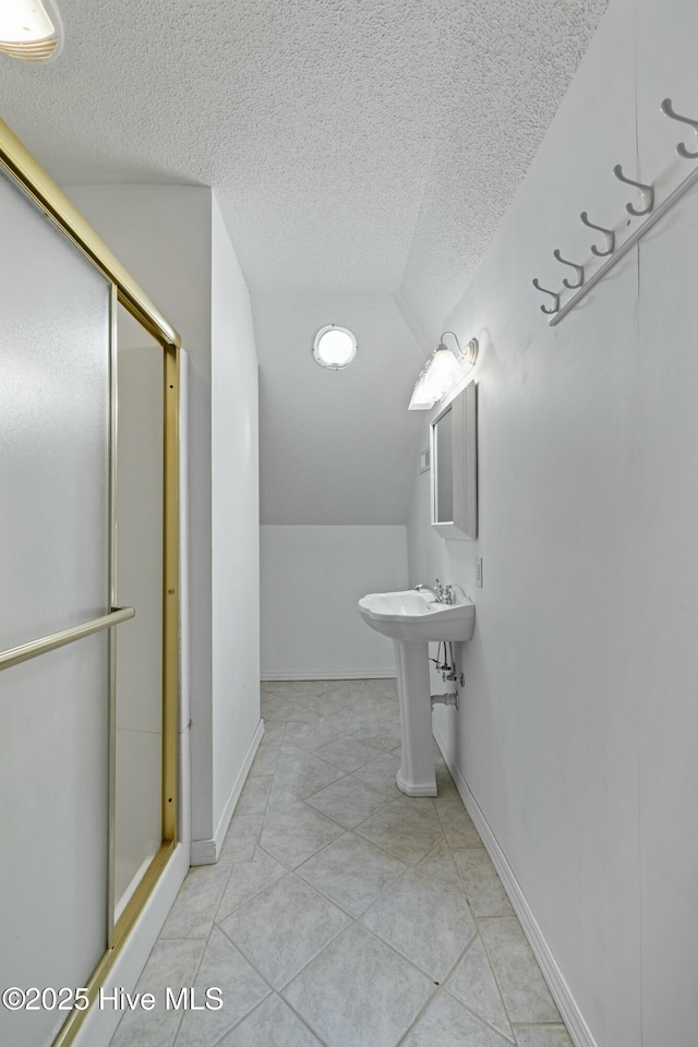 bathroom featuring tile patterned floors, a textured ceiling, a stall shower, and lofted ceiling