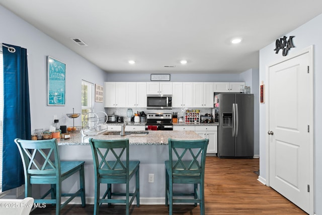 4333 Jones St SW, Shallotte, NC 28470 - kitchen with white cabinetry, a kitchen breakfast bar, stainless steel appliances, and visible vents