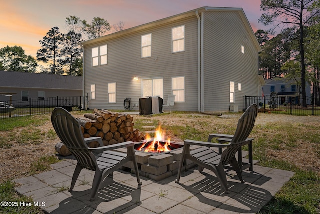4333 Jones St SW, Shallotte, NC 28470 - back of property at dusk featuring a fire pit, a patio area, and fence