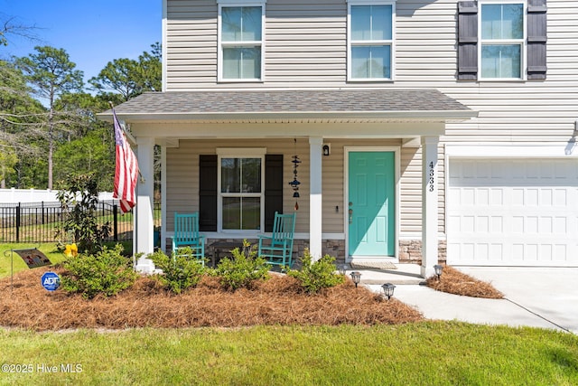 4333 Jones St SW, Shallotte, NC 28470 - view of front of property with driveway, stone siding, covered porch, fence, and roof with shingles