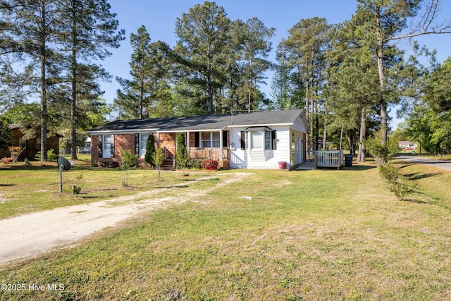 479 W 5th St, Garland, NC 28441 - ranch-style home featuring a front lawn, a wooden deck, and driveway