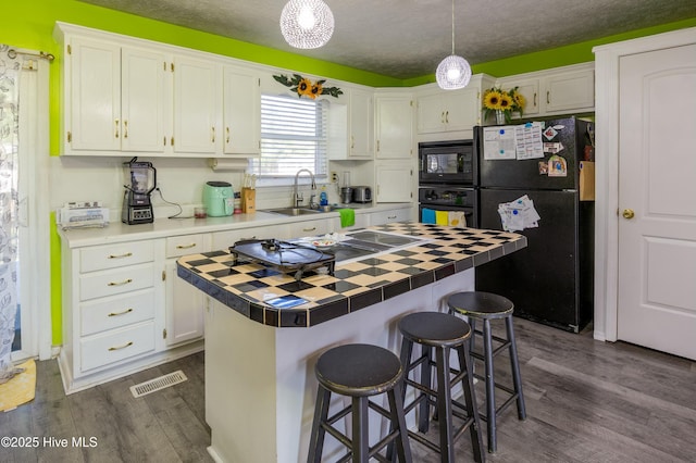 479 W 5th St, Garland, NC 28441 - kitchen featuring white cabinetry, black appliances, a sink, tile counters, and dark wood-style floors