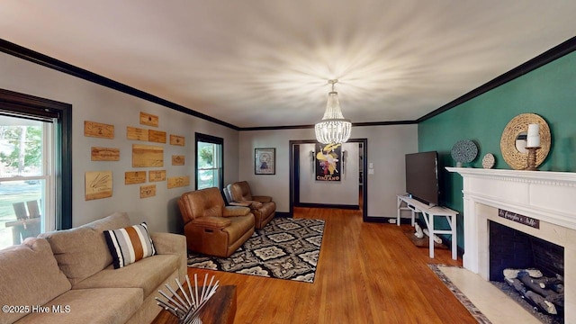 724 York St, Rocky Mount, NC 27803 - living room featuring ornamental molding, wood finished floors, a fireplace, baseboards, and a chandelier