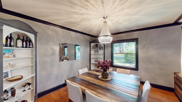 724 York St, Rocky Mount, NC 27803 - dining space with an inviting chandelier, built in features, crown molding, and wood finished floors