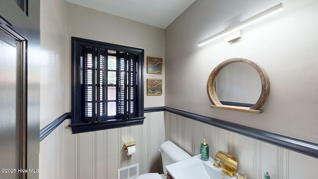 724 York St, Rocky Mount, NC 27803 - half bath with a wainscoted wall, a decorative wall, toilet, and visible vents