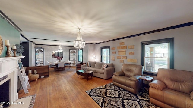 724 York St, Rocky Mount, NC 27803 - living room with an inviting chandelier, ornamental molding, a healthy amount of sunlight, and light wood-type flooring