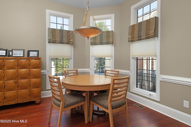 dining space with baseboards, visible vents, and dark wood-style flooring