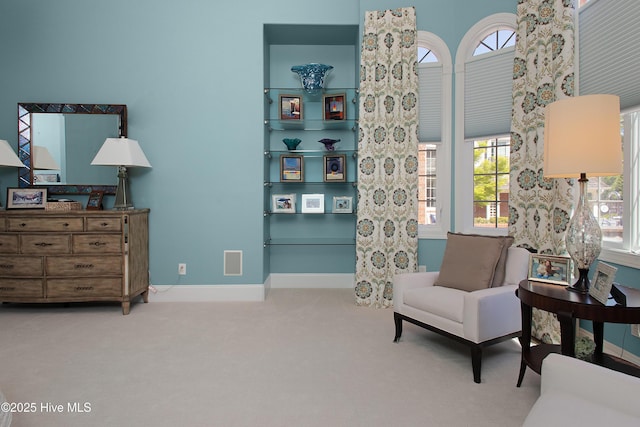 living area with baseboards and carpet