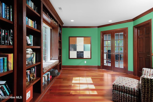 sitting room featuring french doors, baseboards, recessed lighting, wood finished floors, and ornamental molding