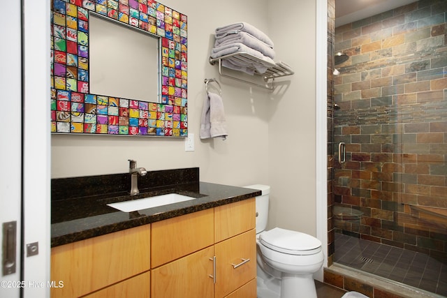 full bath featuring vanity, a shower stall, and toilet