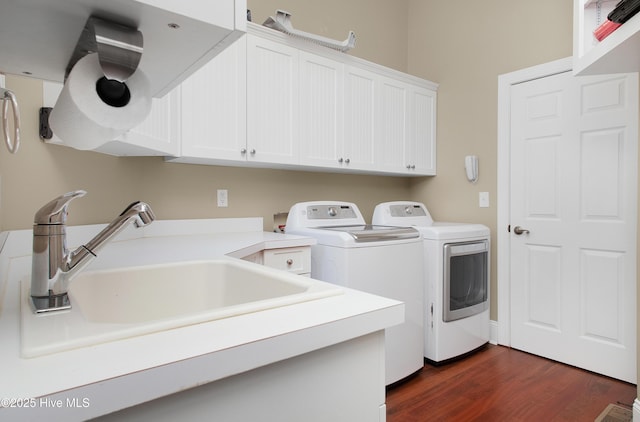 washroom featuring cabinet space, independent washer and dryer, dark wood-style flooring, and a sink