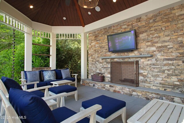 view of patio with a gazebo and an outdoor living space with a fireplace