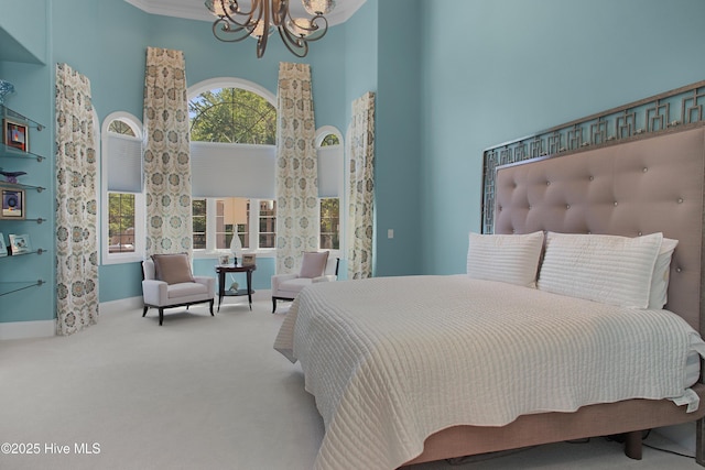 carpeted bedroom with a high ceiling, baseboards, and an inviting chandelier