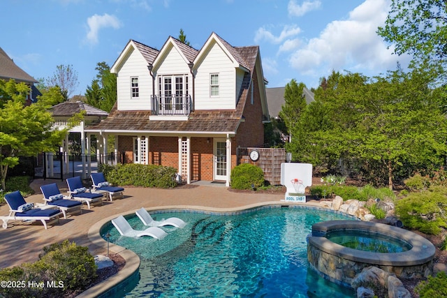 back of house with an exterior structure, a patio area, french doors, brick siding, and a pool with connected hot tub