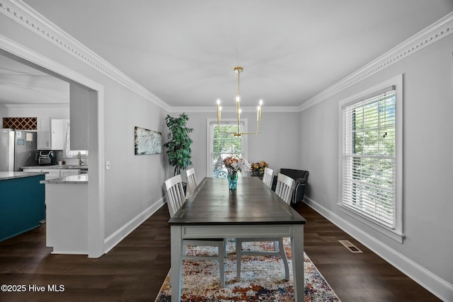 dining area featuring visible vents, baseboards, dark wood-style flooring, a chandelier, and crown molding