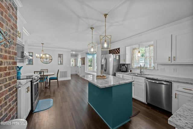 kitchen with crown molding, dark wood finished floors, white cabinets, appliances with stainless steel finishes, and a sink